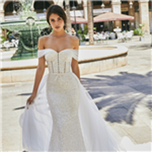 Model wearing Ronald Joyce wedding dress style 69722, an off the shoulder pearl-beaded fit and flare wedding gown